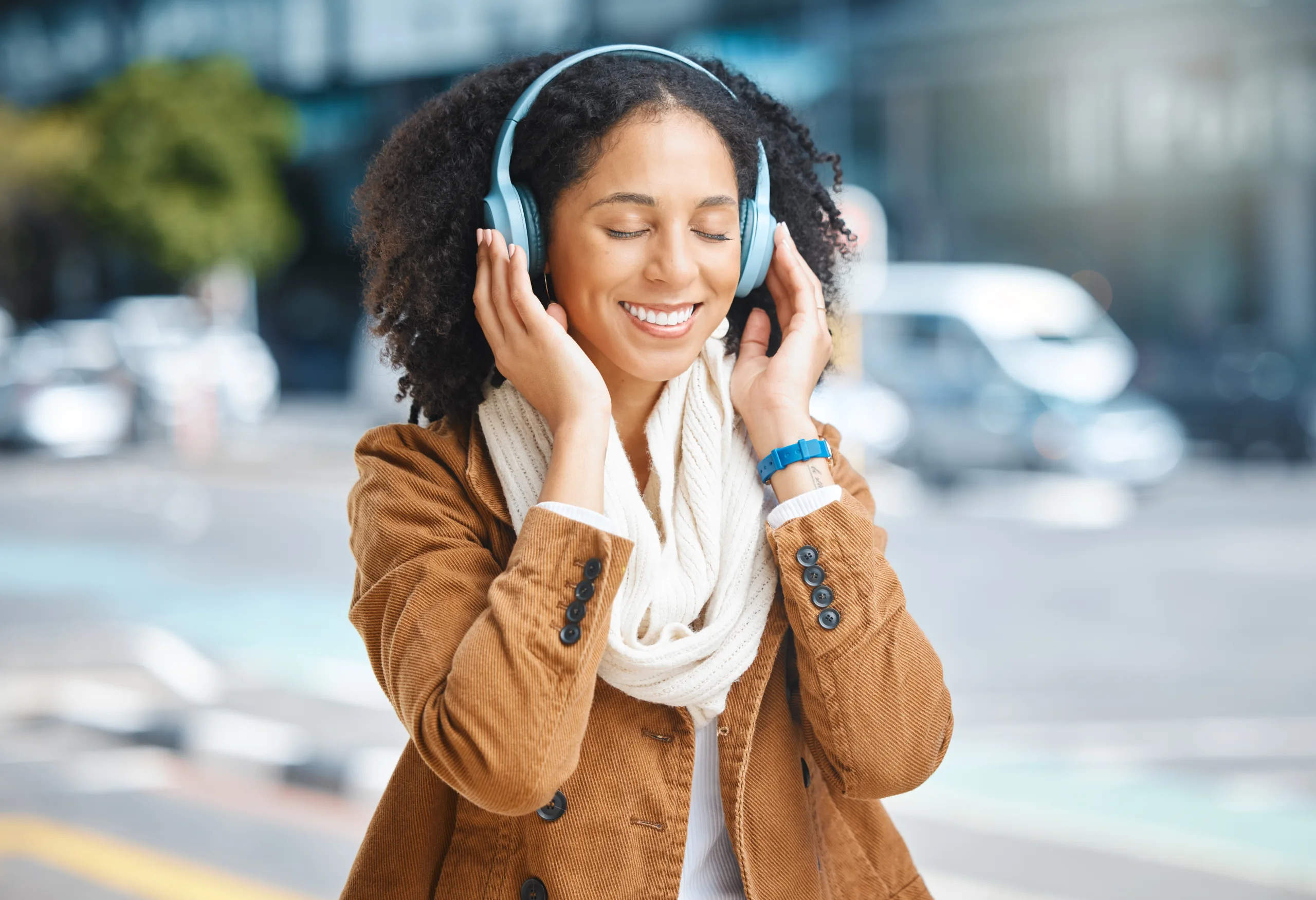 Music, headphones and black woman happy in city for travel, motivation and mindset. Young person on.