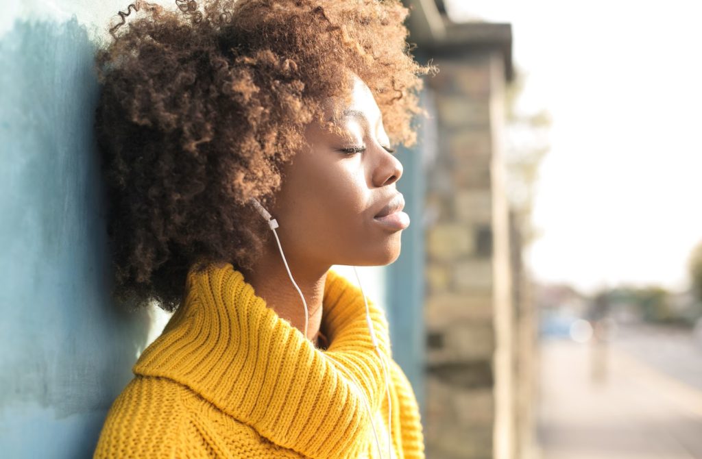 Beautiful girl relaxing listening music in the street