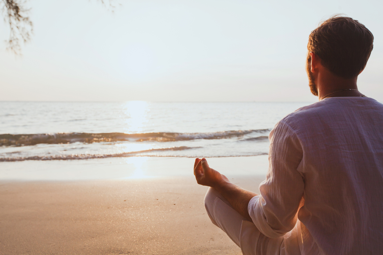 meditation, man practicing yoga at sunset beach, background with copy space